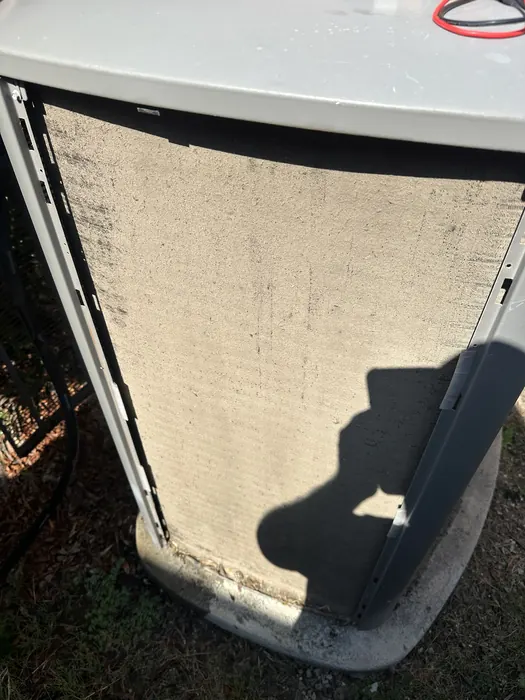 Outdoor AC condenser coil caked with dirt and debris