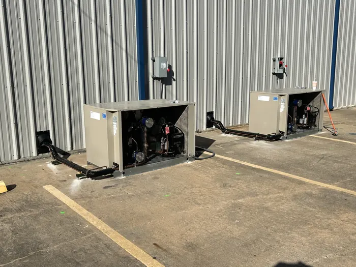 Ground-mounted refrigeration condensing units outside a cold storage building